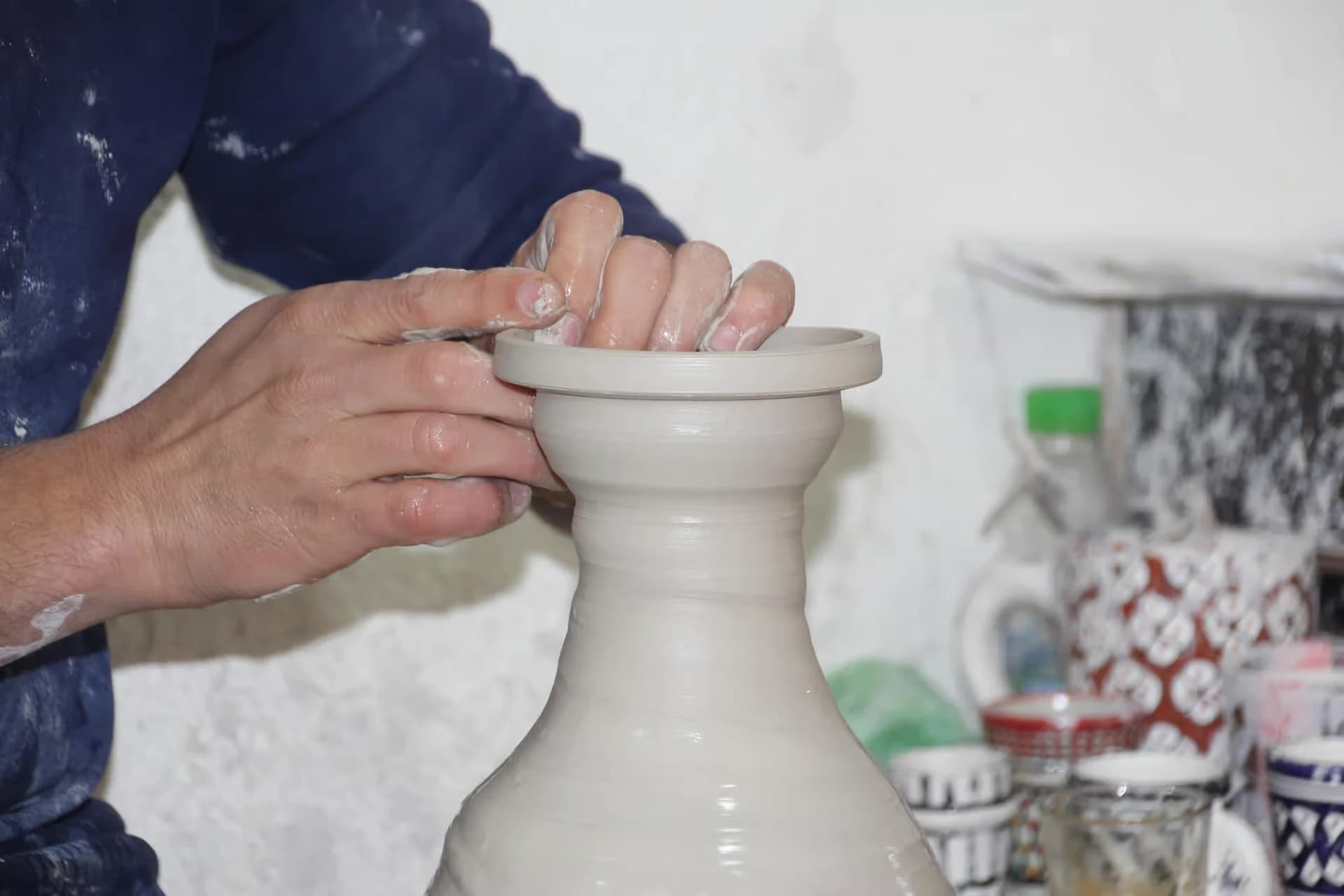 Guest dressed for craft work at a pottery table in Fes